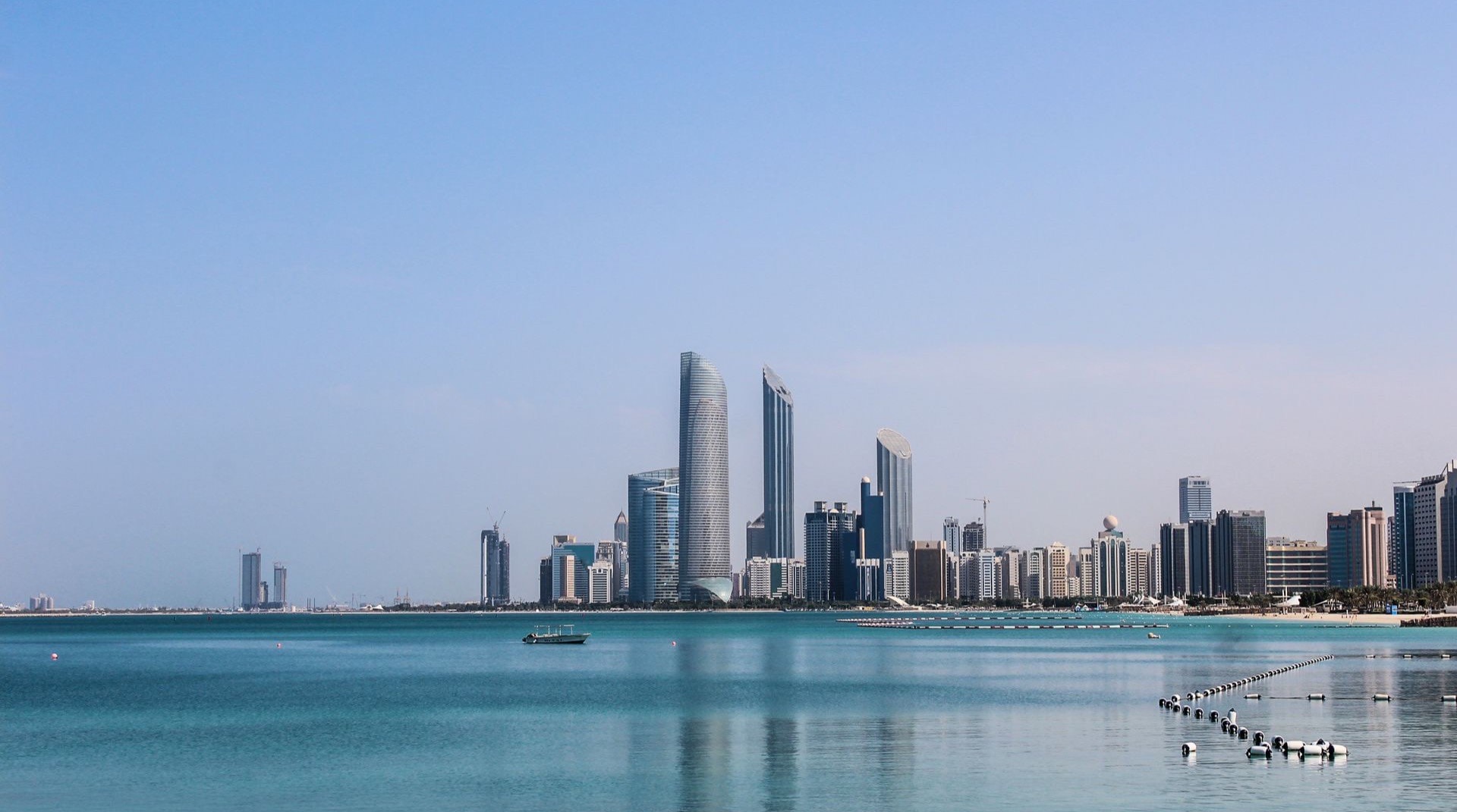 Skyline von Abu Dhabi mit Corniche und modernen Wohntürmen bei Abenddämmerung