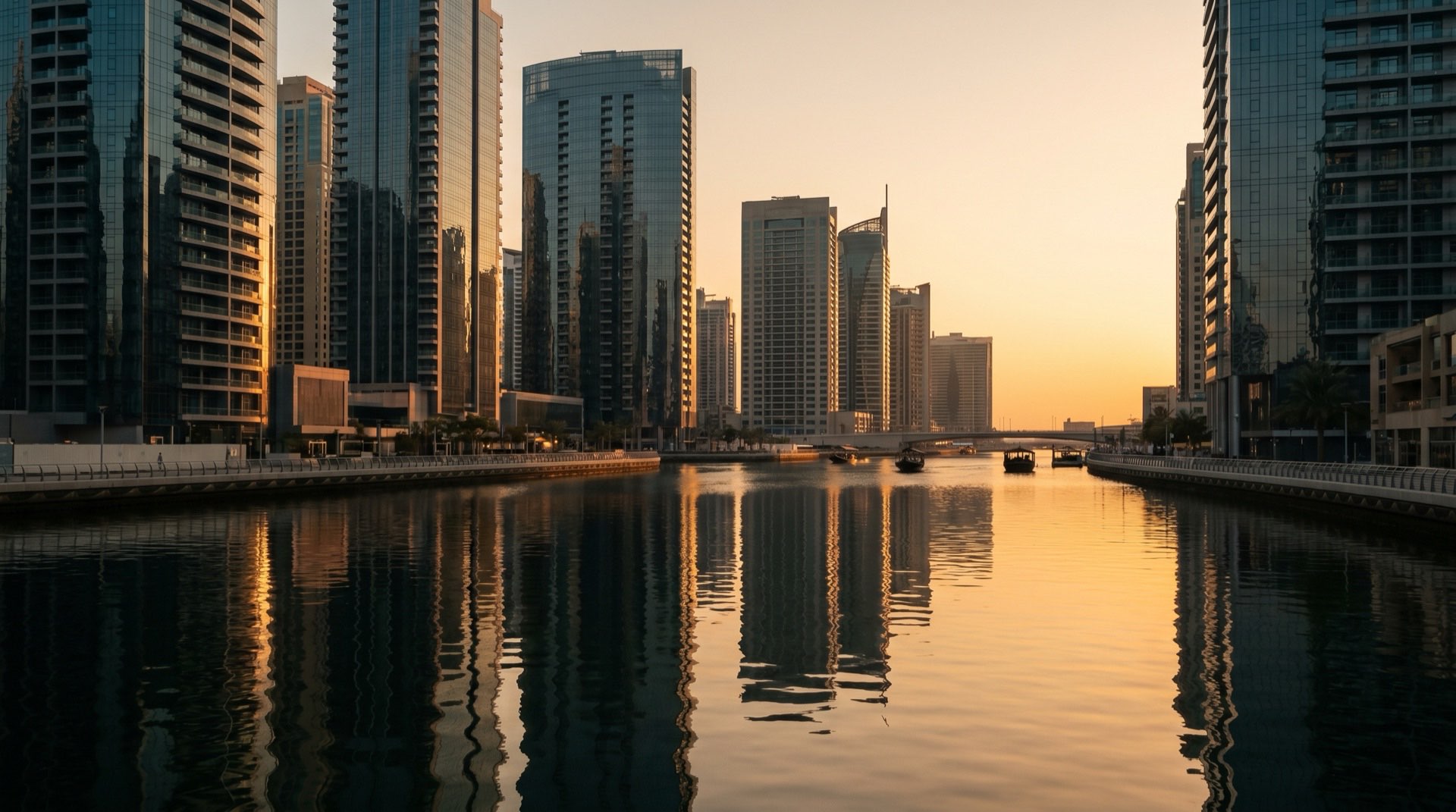 Moderne Hochhausfassaden in Dubai im goldenen Nachmittagslicht, Blick von einer Glasterrasse auf die Skyline