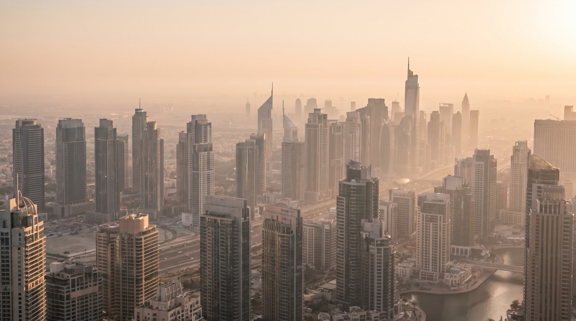 Moderne Hochhausfassade in Dubai im goldenen Abendlicht, geometrische Glasstruktur mit ruhiger Komposition