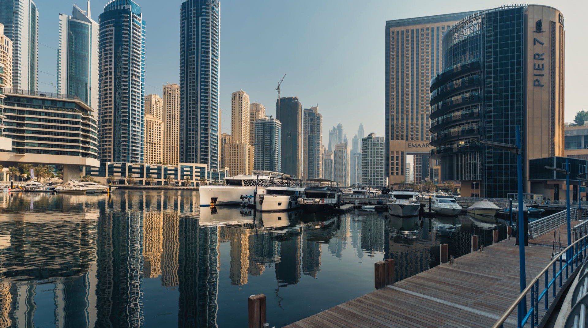 Blick auf die Yachthäfen von Mina Rashid mit der Waterfront-Promenade im Abendlicht