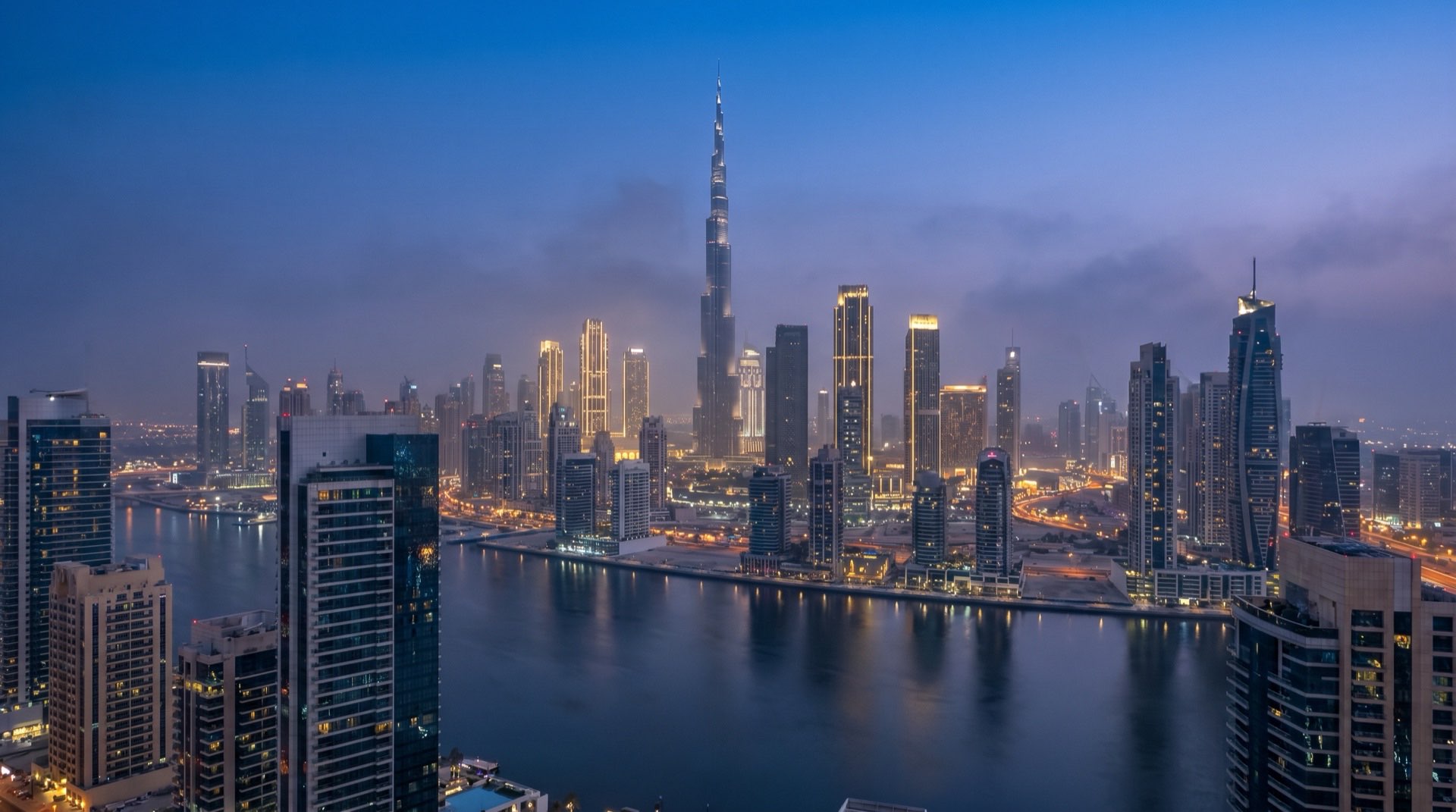 Moderne Bürotürme im Business Bay-Viertel von Dubai im goldenen Abendlicht, ruhige Promenade im Vordergrund